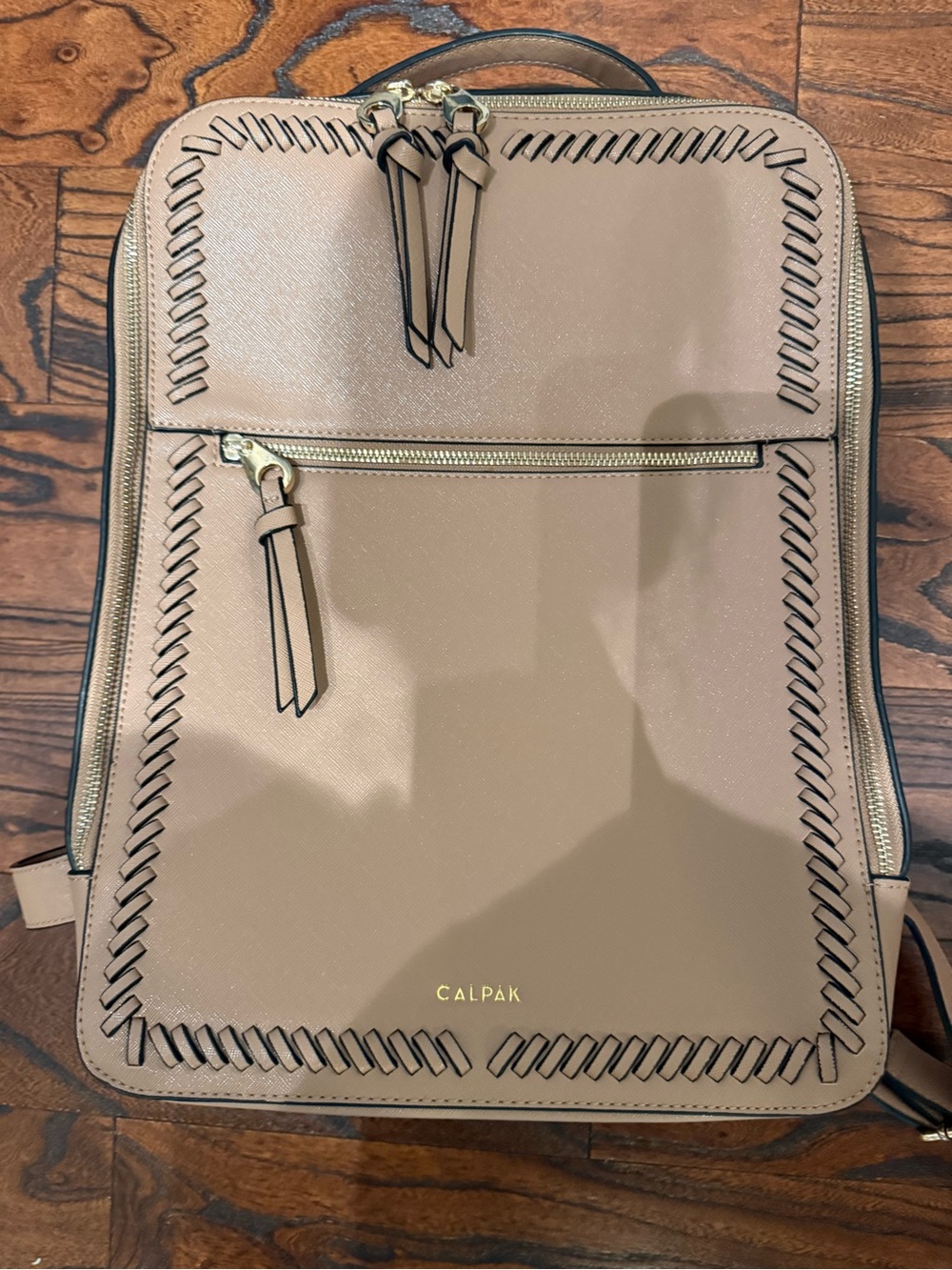 Calpak taupe backpack with whipstitch trim and gold hardware
